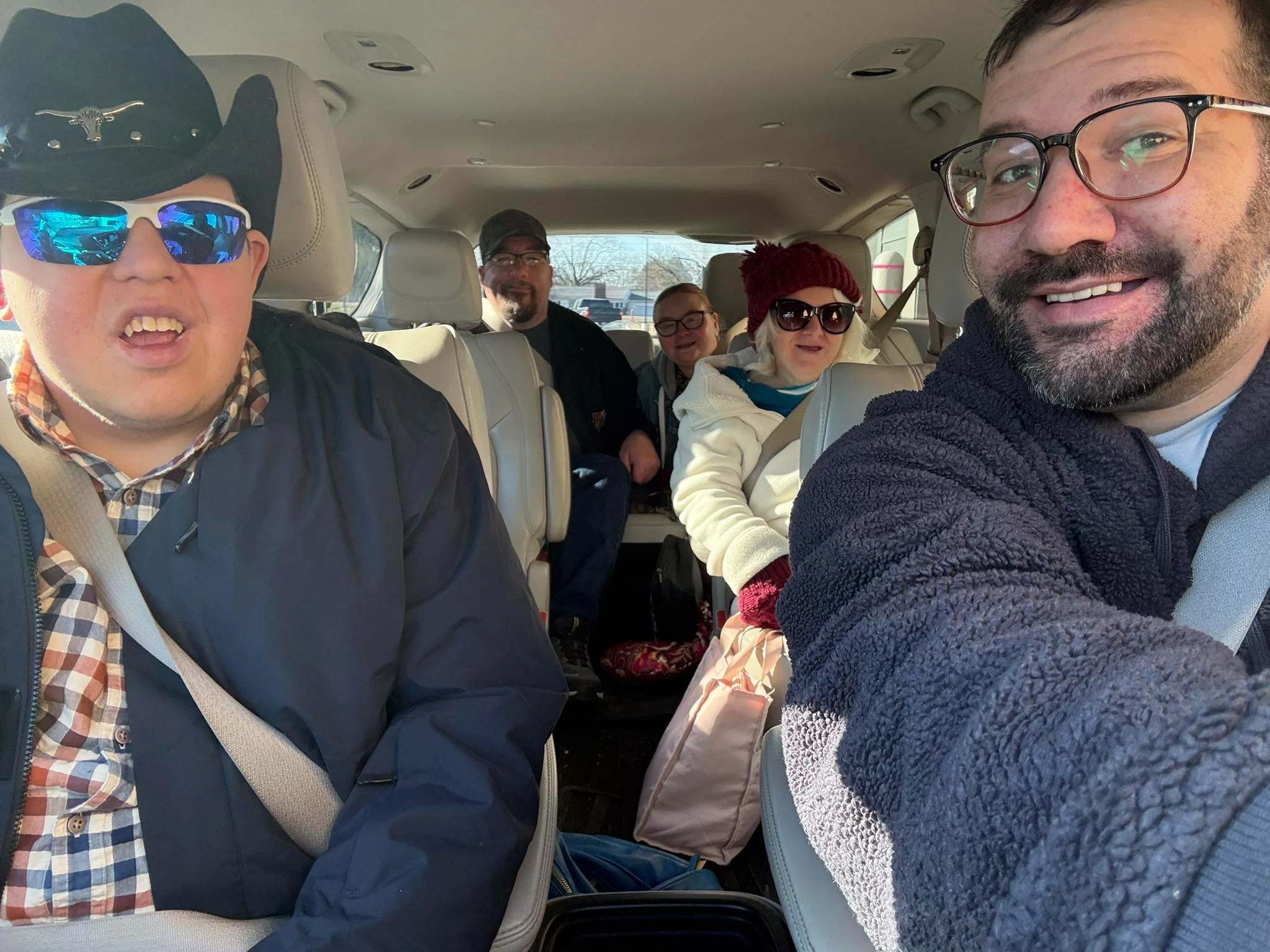 Five people smiling in a van