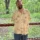 Tyler smiling with a wooded area behind him